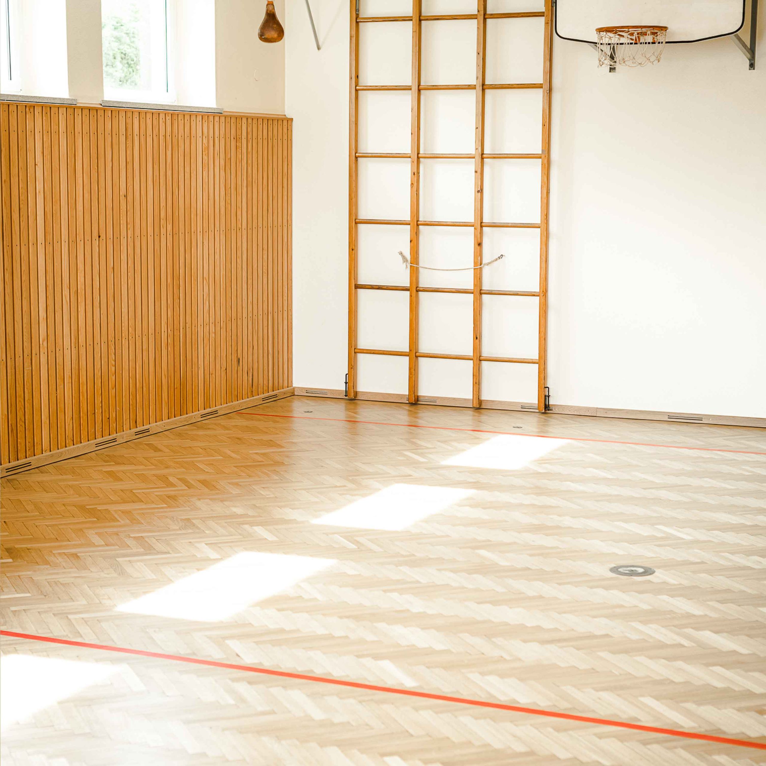 Bild zeigt Sporthalle mit neu verlegtem Holzboden und Bodenmarkierung.