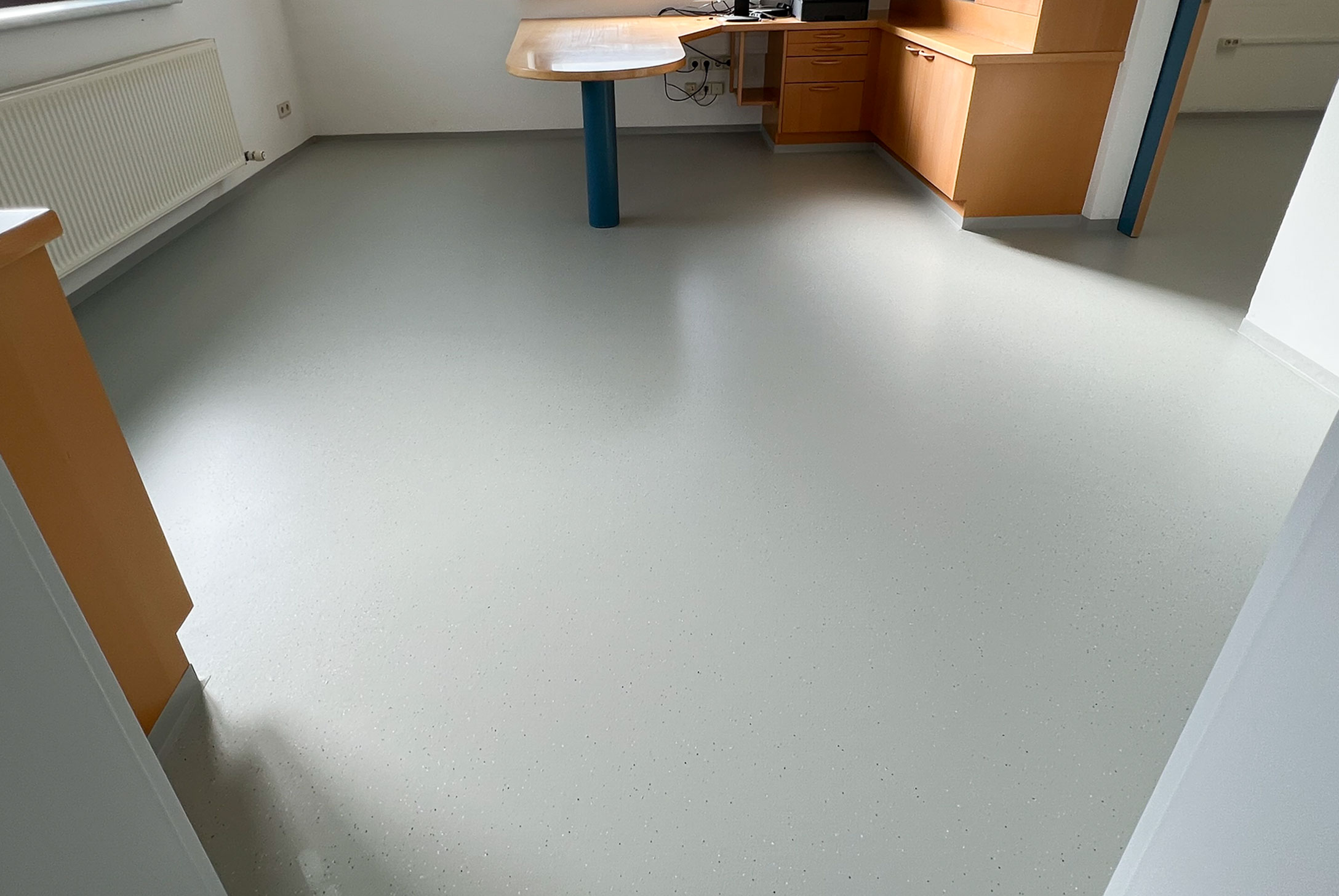 Bild zeigt frisch sanierten grauen Kunststoffboden einer Arztpraxis