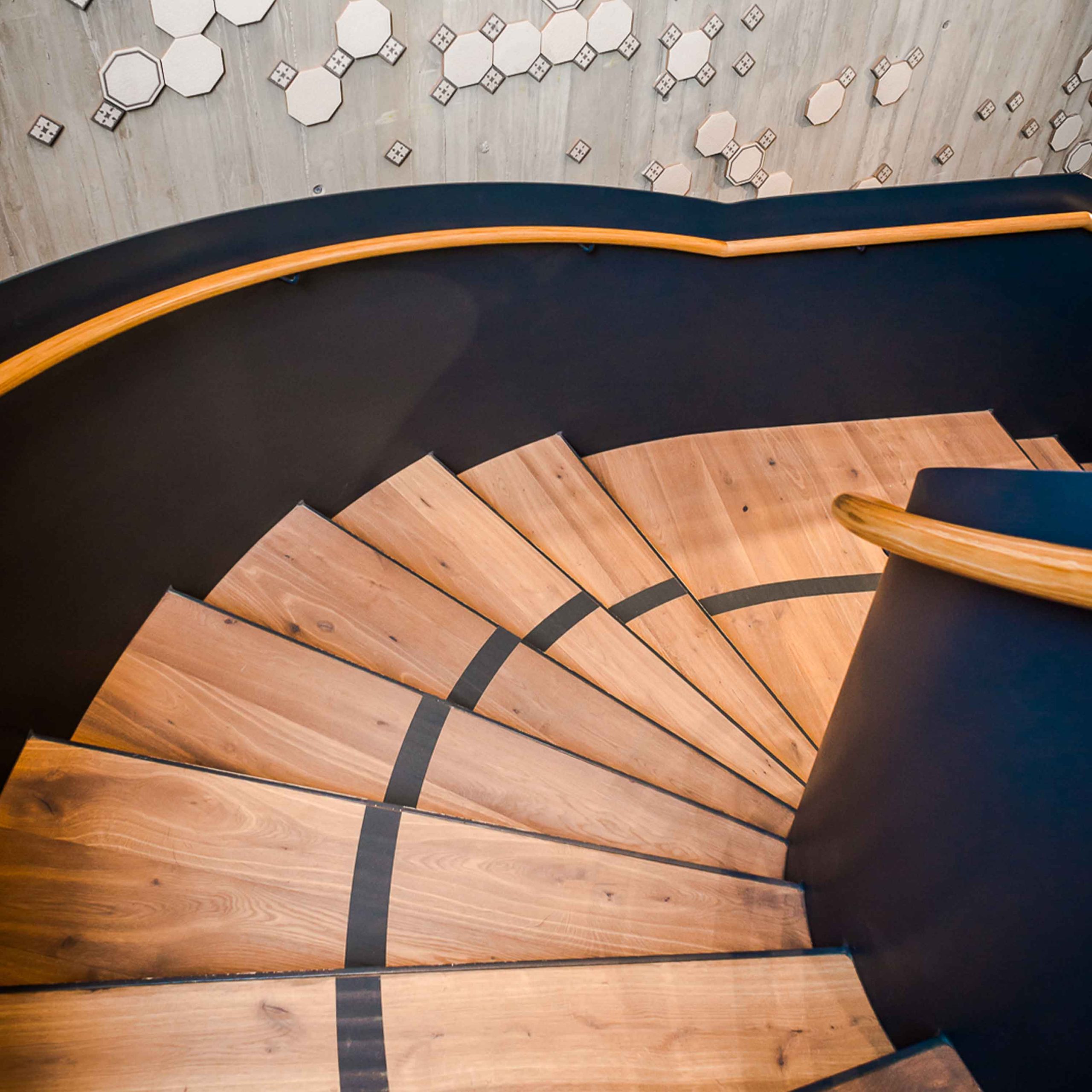 Bild zeigt Treppenabgang des neu verlegten Holzbodens mit Leitsystem-Beklebung im Merkur Lifestyle Gym.