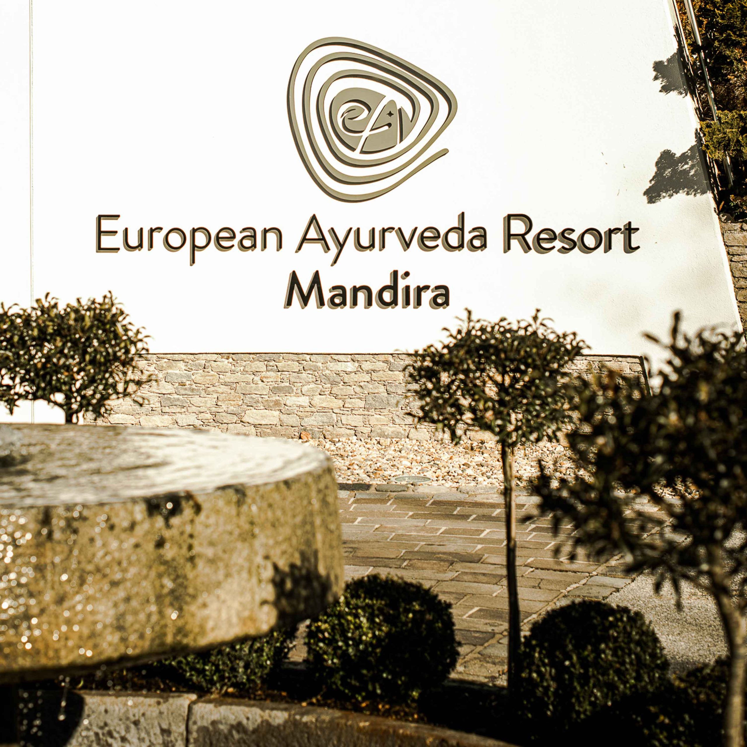 Bild zeigt Außenbereich mit Logo des Ayurveda Resort Mandira in der Steiermark.