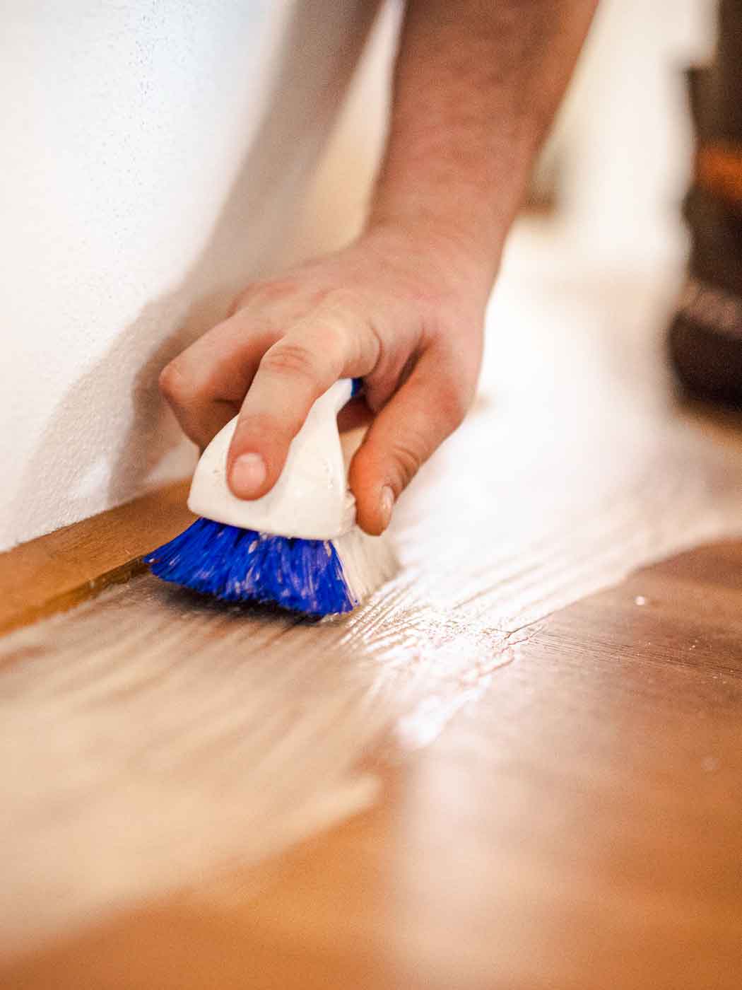 Bild zeigt Detailfoto beim Bürsten bzw. Sanieren eines Holzbodens.