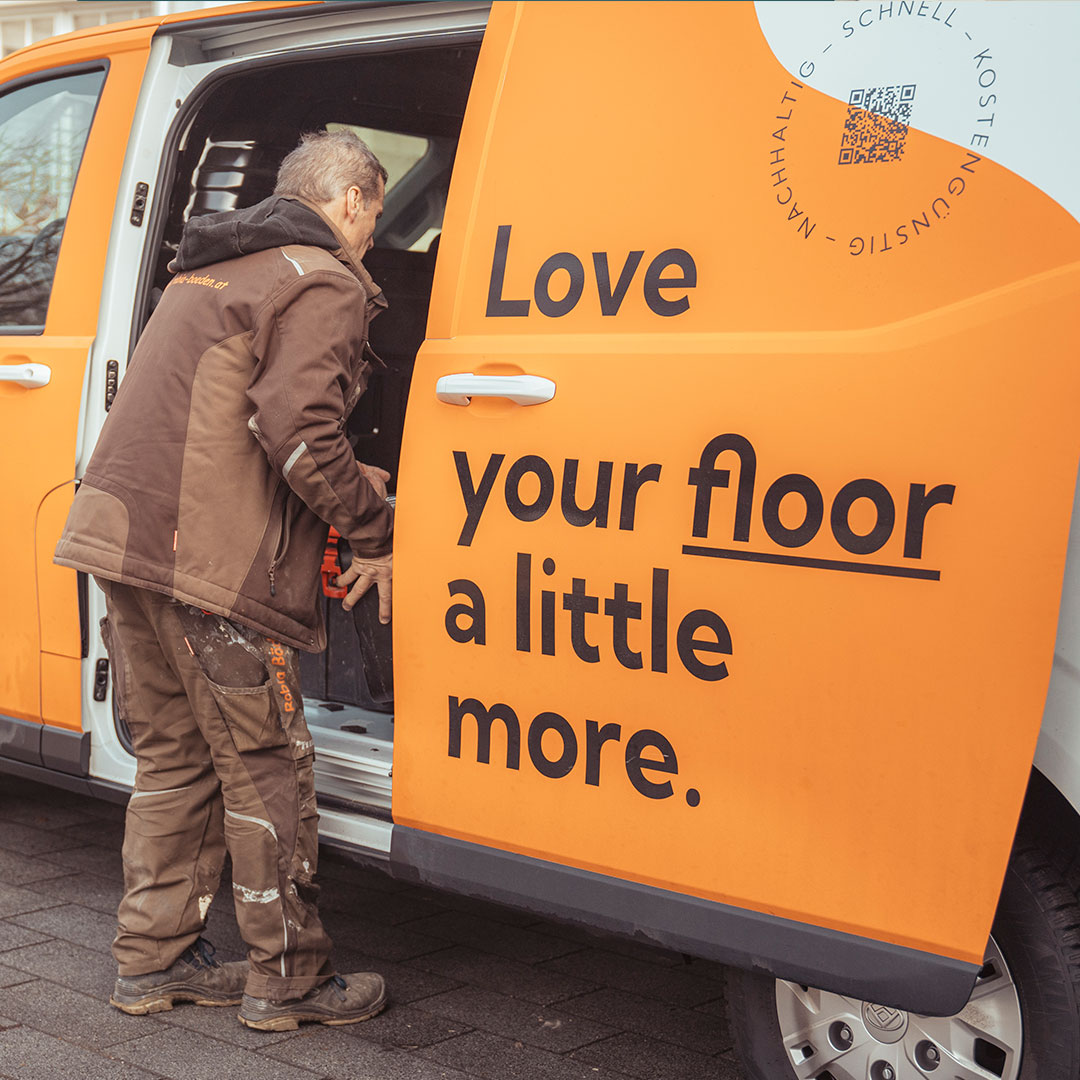 Bild zeigt arbeitenden Mann vor offener Schiebetüre eines E-Autos.